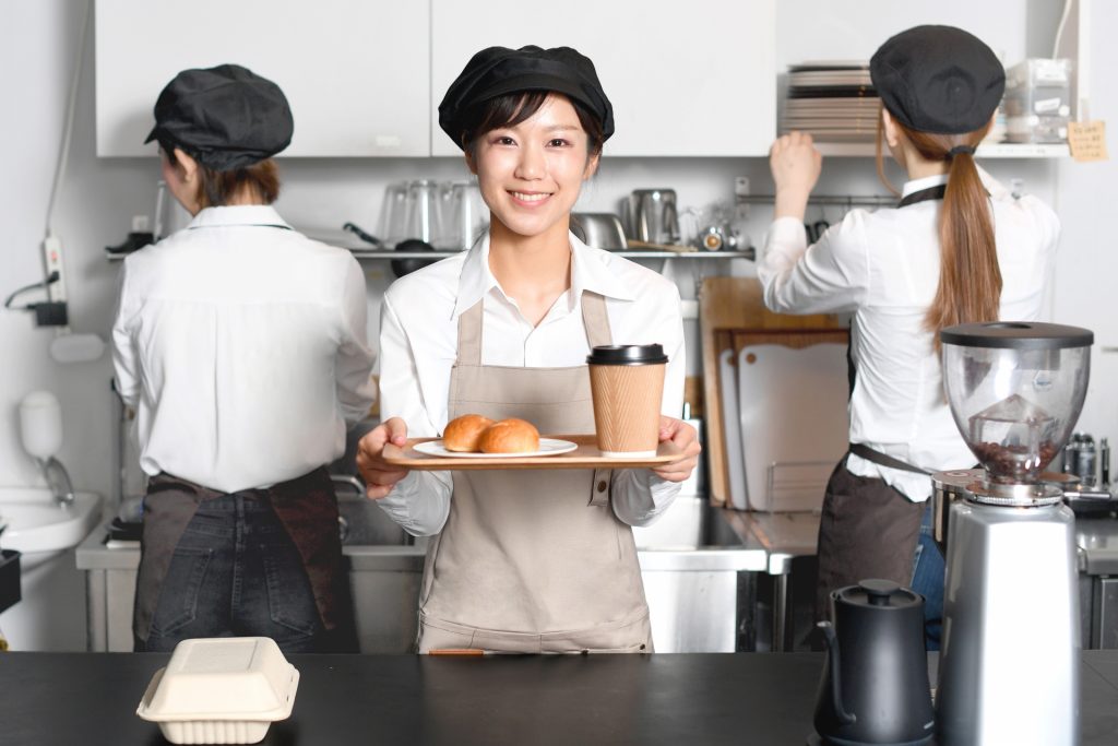 飲食店の店員が食品を持っている画像